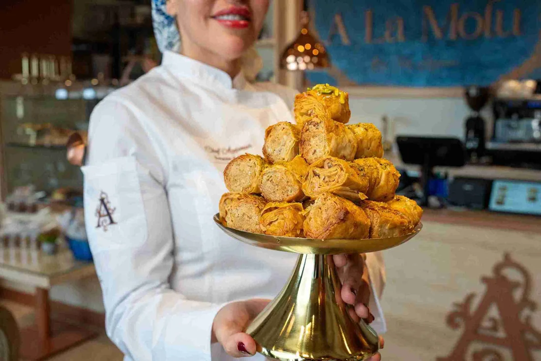 Chef Ayşenur holding a pastry platter